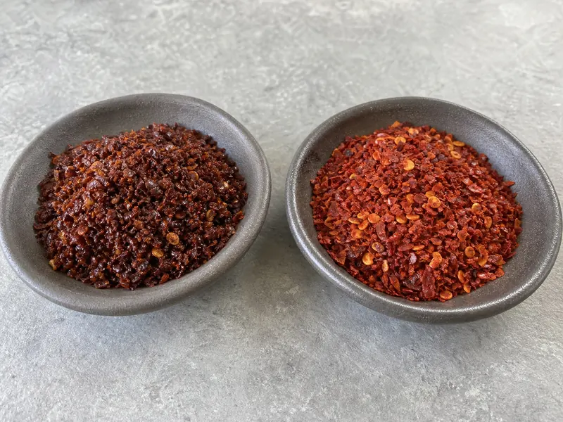Close comparison of dark Maras flakes and brighter Aleppo flakes in separate dishes