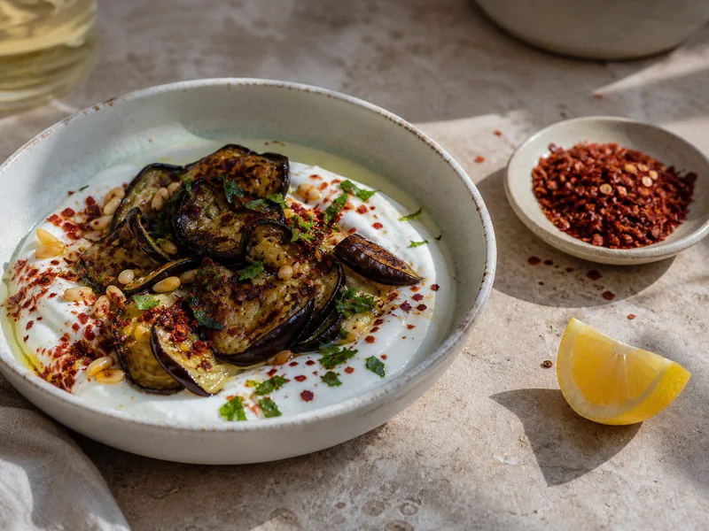 Aleppo pepper flakes finishing grilled eggplant and yogurt