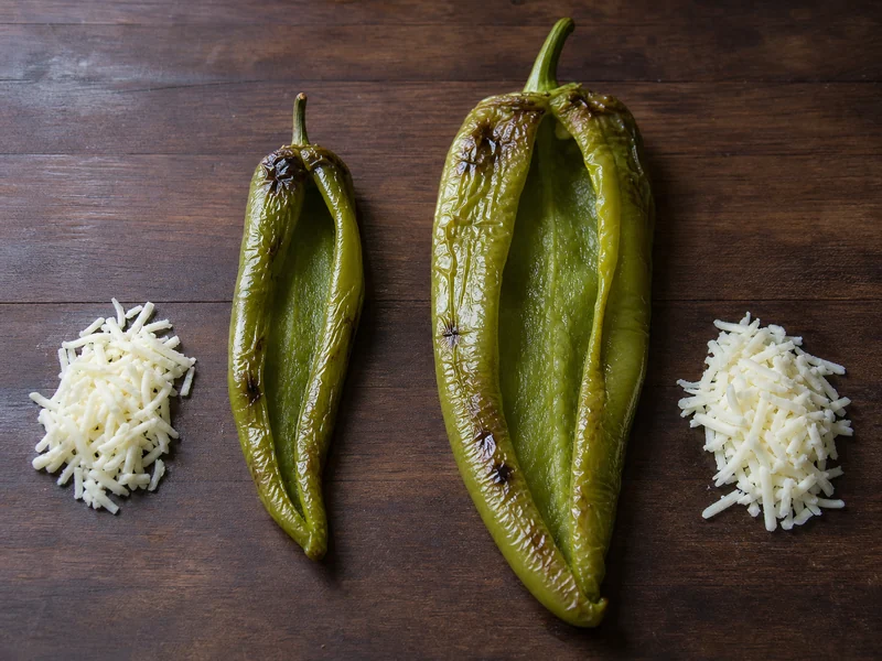 Opened Anaheim and NuMex Big Jim peppers showing different stuffing cavity sizes
