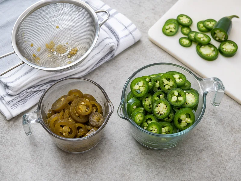 Drained canned jalapeno rings and sliced fresh jalapenos measured in separate cups
