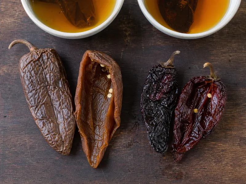 Rehydrated chipotle meco and morita pods opened to show their different color and texture