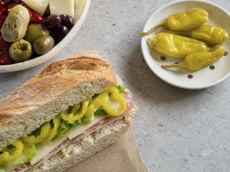 Brined pepperoncini finishing an Italian deli sandwich