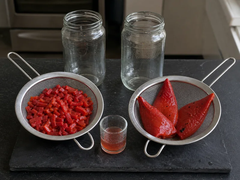 Diced pimento and whole roasted piquillo peppers draining in separate strainers