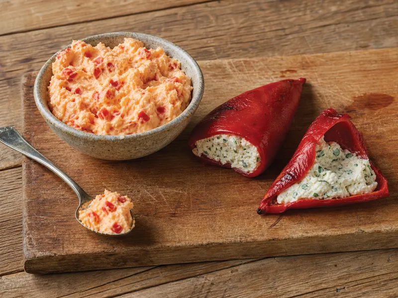 Pimento cheese spread beside cheese-filled roasted piquillo peppers