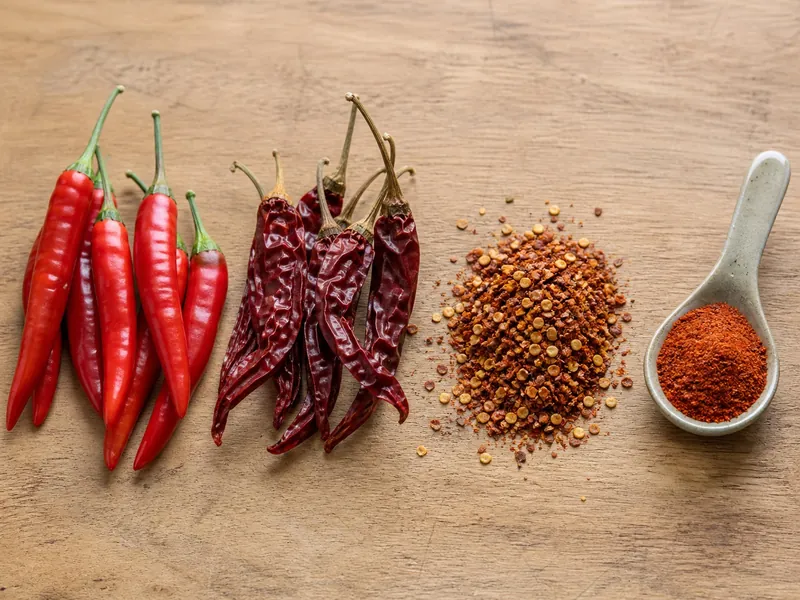 Fresh and dried cayenne chilies with flakes and ground powder