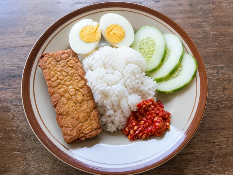 Sambal oelek served beside rice, tempeh, egg, and cucumber