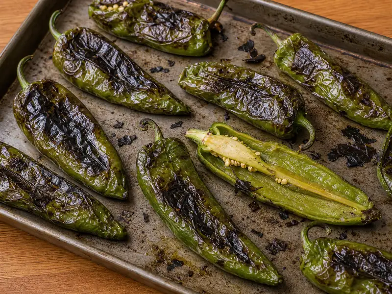 Roasted Anaheim chiles with blistered skins and one pod opened